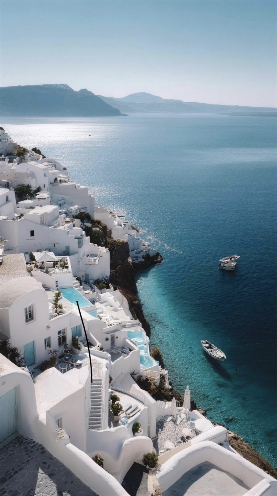 Whitewashed houses cascading down the cliffs above the sea in Santorini, Greece