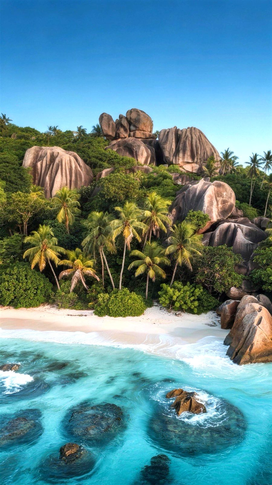 Granite boulders and palm trees above a turquoise lagoon in the Seychelles