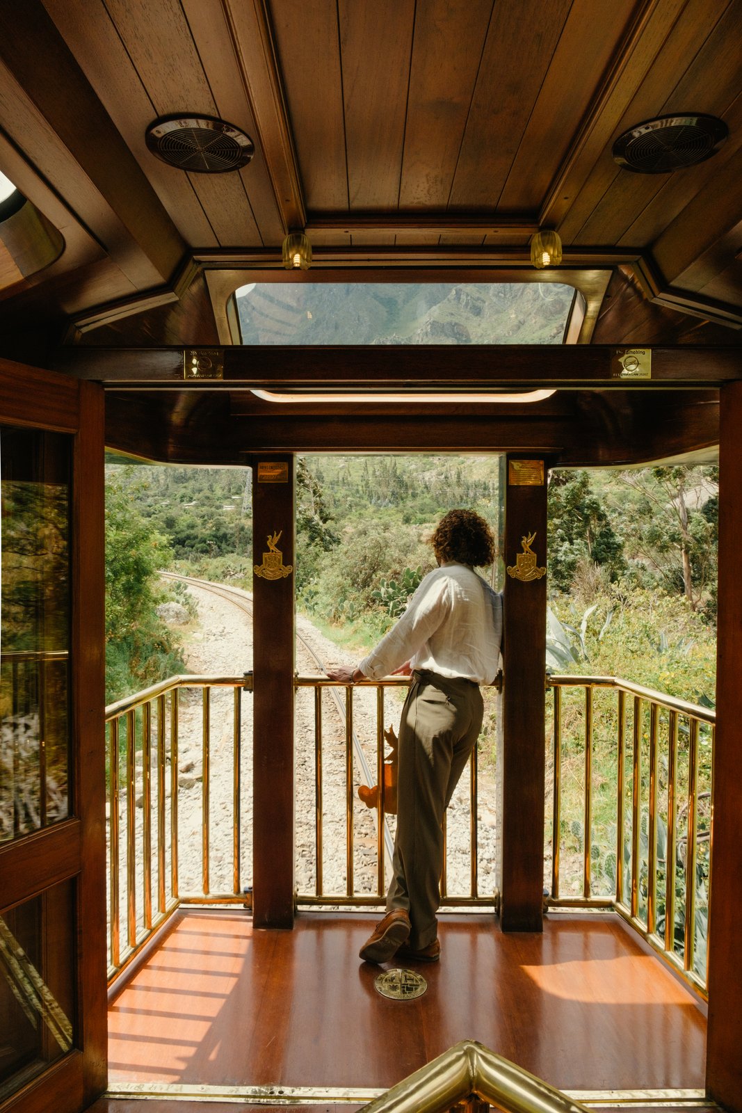 A guest on the observation deck of a Belmond train in the Andes