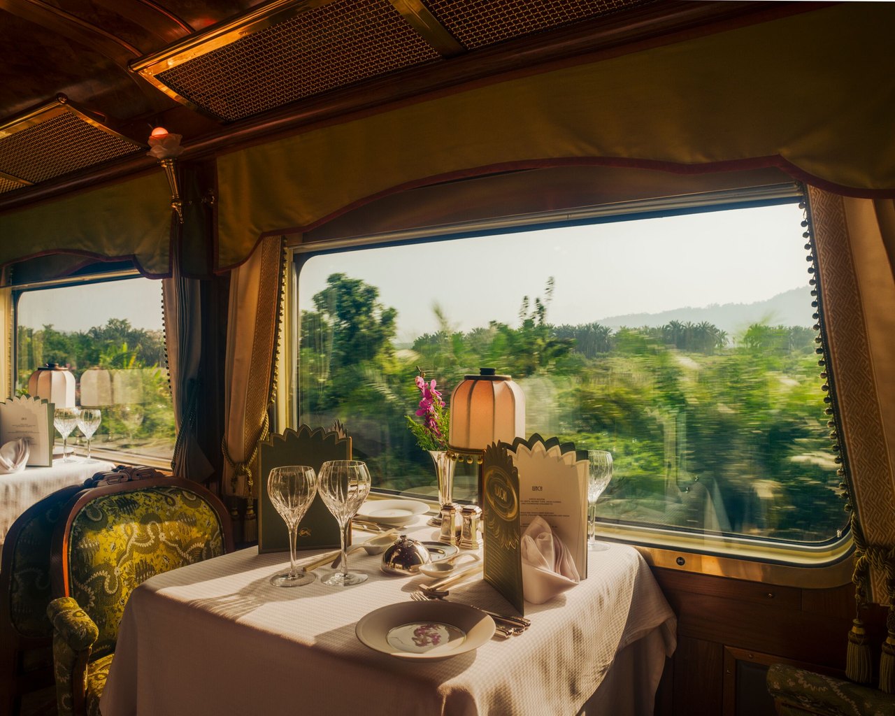 A dining car table set for dinner beside the window