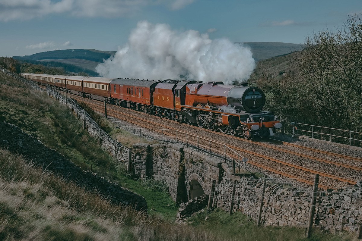 A steam locomotive hauling the Northern Belle through the English countryside