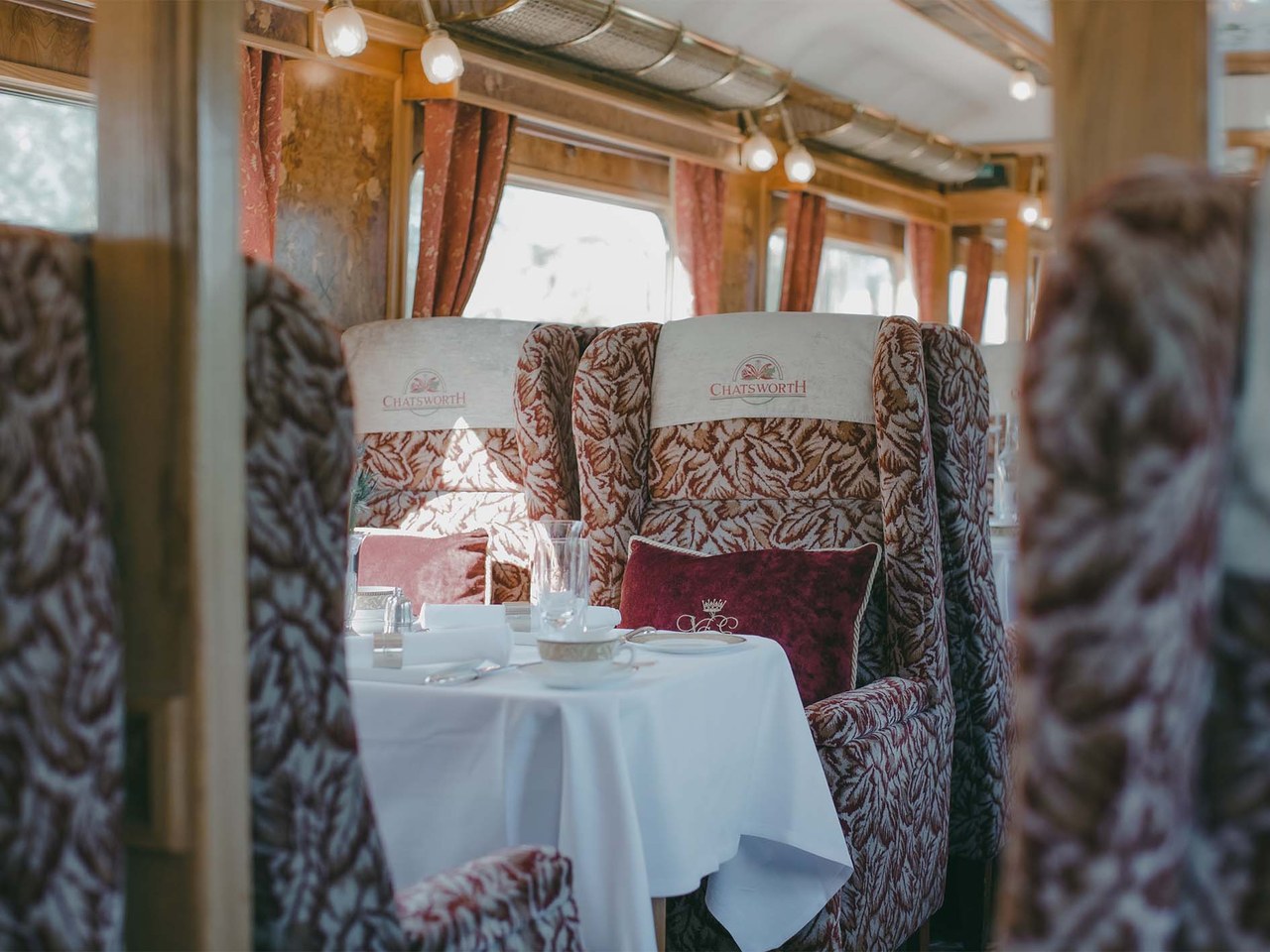 Wingback armchairs around a laid table in the Northern Belle&rsquo;s Chatsworth carriage